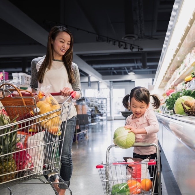 Mother and daughter shopping in a super market for produce